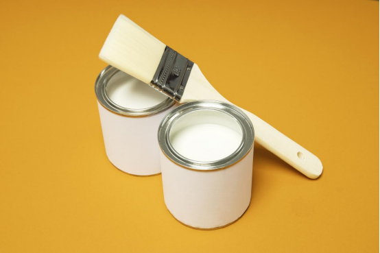 Two buckets of paint with Texanol and a brush